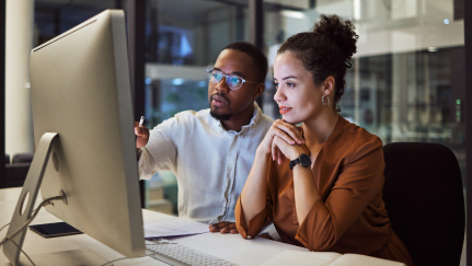 Cybersecurity 201: Two individuals looking at a desktop computer screen.