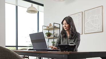 woman sitting at a desk and working on a laptop